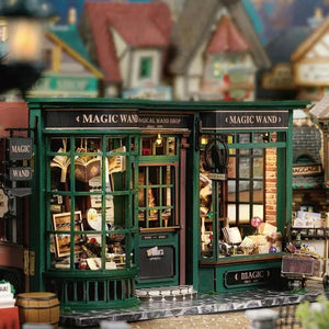 Illuminated front exterior view of the DIY Magic Wand Shop miniature house kit with green and red accents.